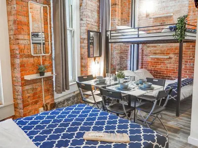 a dining room with a table and chairs and a brick wall at Metropolitan Studio Apartments Manhattan in New York