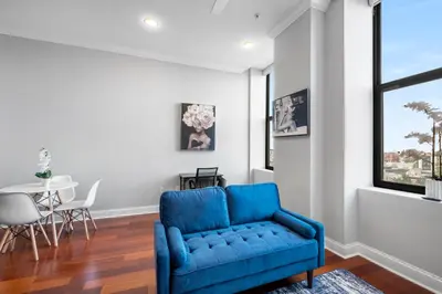 a blue couch in a living room with a table at Palatial 1BR with Rooftop Pool in Philadelphia