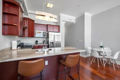 a kitchen with a counter with chairs and a table at Palatial 1BR with Rooftop Pool in Philadelphia