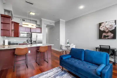 a living room with a couch and a kitchen at Palatial 1BR with Rooftop Pool in Philadelphia