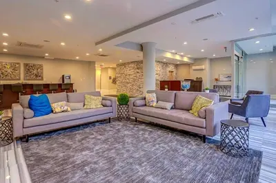 a living room with two couches and a table at Palatial 1BR with Rooftop Pool in Philadelphia