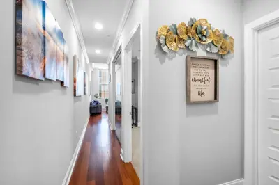 a hallway with white walls and paintings on the walls at Sleek 1BR with Rooftop Amenities in Philadelphia