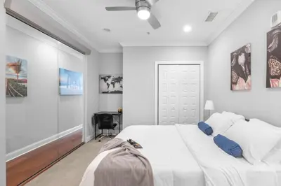a white bedroom with a bed and a desk at Sleek 1BR with Rooftop Amenities in Philadelphia