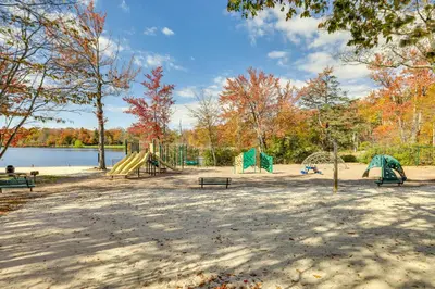 a park with playground equipment and trees and a lake at Near Water Parks Pet-Friendly Tobyhanna Getaway! in Tobyhanna