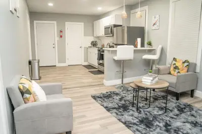 a living room with two chairs and a kitchen at Divine Villa and Resort -26 Grace Street Irvington NJ -EWR airport -Prudential - NJIT -Penn station in Irvington