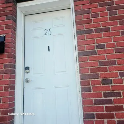 a white door with the number on it on a brick building at Divine Villa and Resort -26 Grace Street Irvington NJ -EWR airport -Prudential - NJIT -Penn station in Irvington