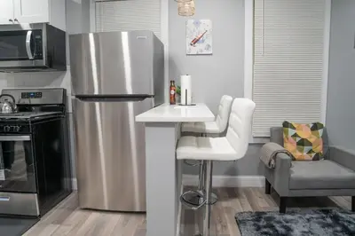 a kitchen with a stainless steel refrigerator and a sink at Divine Villa and Resort -26 Grace Street Irvington NJ -EWR airport -Prudential - NJIT -Penn station in Irvington