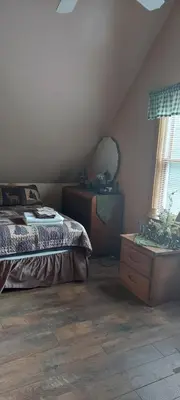 a bedroom with a bed and a dresser and a window at The Old Tioga Inn Bed and Breakfast in Fairmount Springs