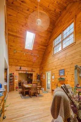 a living room with a wooden ceiling with a table and chairs at The Old Tioga Inn Bed and Breakfast in Fairmount Springs