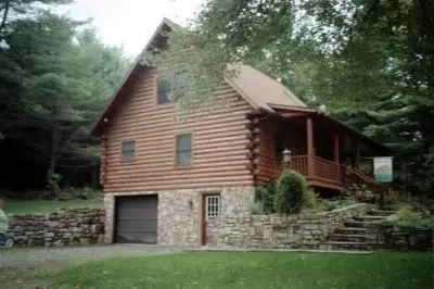 a large wooden house with a garage in the yard at The Old Tioga Inn Bed and Breakfast in Fairmount Springs