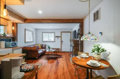 a living room with a table and a couch at Poconos Cabin Year Round Bliss in Greentown