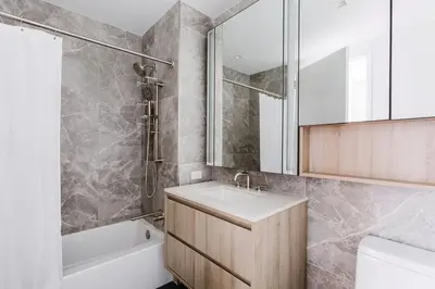 a bathroom with a sink and a tub and a toilet at Blueground Midtown West gym doorman wd NYC-1560 in New York