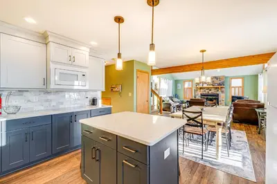 a kitchen with blue cabinets and a dining room at Lakefront Cabin Kayaks, Paddle Boards and Fishing in Pocono Lake