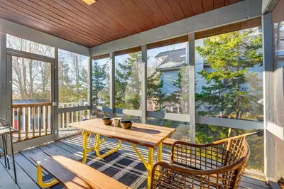 a screened in porch with a wooden table and chairs at Lakefront Cabin Kayaks, Paddle Boards and Fishing in Pocono Lake