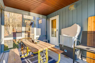 a porch with a wooden table and a chair at Lakefront Cabin Kayaks, Paddle Boards and Fishing in Pocono Lake