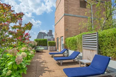 a patio with blue lounge chairs and a building at Blueground Jersey City 1bd apartment NYC-1603 in New York