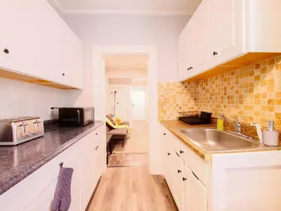 a kitchen with white cabinets and a sink at Serene Two-Bedroom Retreat - close to NYC in Jersey City