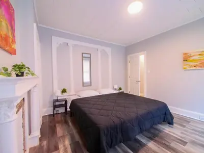 a bedroom with a large bed and a fireplace at Serene Two-Bedroom Retreat - close to NYC in Jersey City