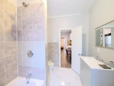 a bathroom with a shower and a sink and a mirror at Serene Two-Bedroom Retreat - close to NYC in Jersey City
