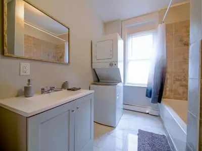 a bathroom with a sink and a white refrigerator at Serene Two-Bedroom Retreat - close to NYC in Jersey City