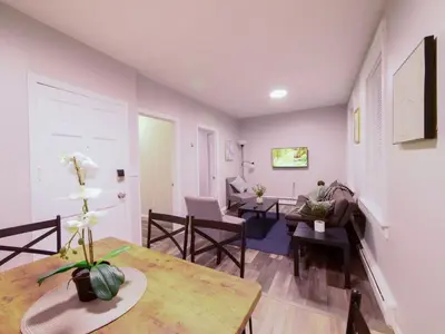 a living room with a table and a couch at Modern comfort-2BR haven mins to NYC in Jersey City