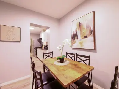 a dining room with a wooden table and chairs at Modern comfort-2BR haven mins to NYC in Jersey City