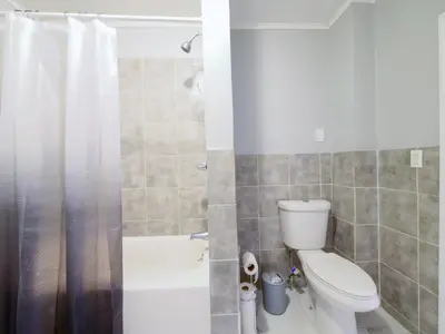 a bathroom with a white toilet and a shower at Modern comfort-2BR haven mins to NYC in Jersey City