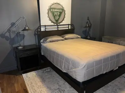 a bedroom with a bed and two night stands and a lamp at the old soda factory in Mount Carmel