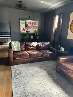 a living room with a brown leather couch at the old soda factory in Mount Carmel