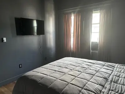 a bedroom with a bed and a television on the wall at the old soda factory in Mount Carmel