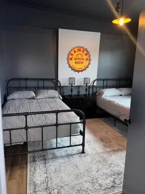 a bedroom with two beds and a sign on the wall at the old soda factory in Mount Carmel