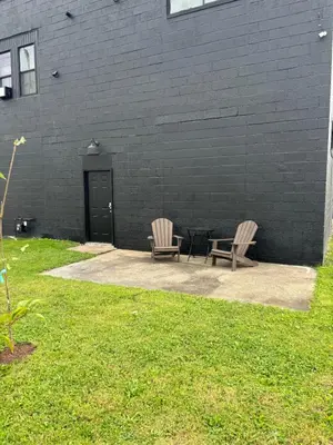 two chairs sitting next to a black brick building at the old soda factory in Mount Carmel