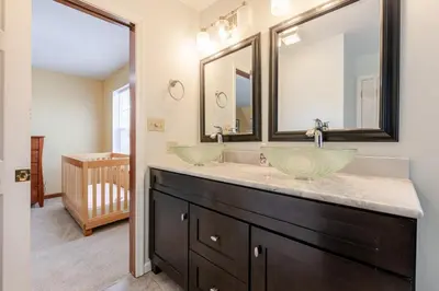 a bathroom with two sinks and two mirrors at Mountain View-Steam Shower-2 Tier Patio- King Bed in Northampton