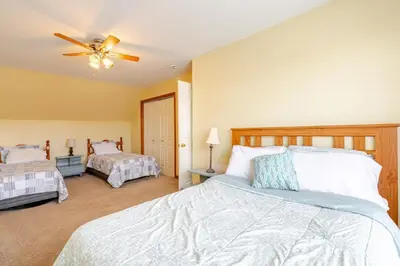 a bedroom with two beds and a ceiling fan at Mountain View-Steam Shower-2 Tier Patio- King Bed in Northampton