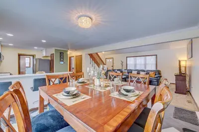a dining room and living room with a table and chairs at The Gap at Poconos- Sun Room-Arcade- Game Room in Long Pond