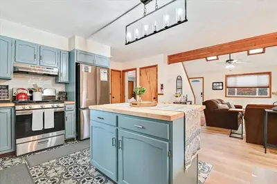 a kitchen with blue cabinets and a living room at Rustic Modern Retreat in Poconos in Albrightsville