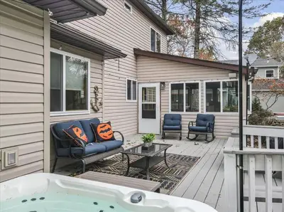 a patio with a couch and a table and a tub at Rustic Modern Retreat in Poconos in Albrightsville