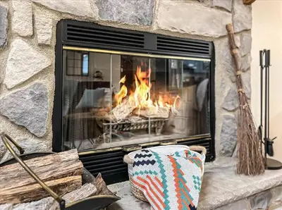 a stone fireplace with a fire in it at Rustic Modern Retreat in Poconos in Albrightsville
