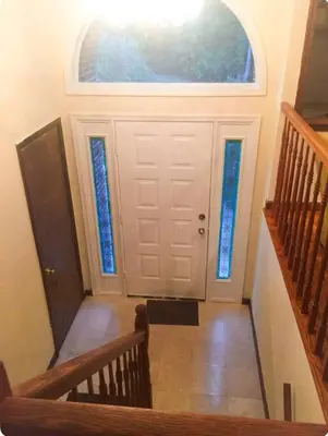 a staircase leading to a white door with a window at 2000 square feet of comfort and relaxation near NYC in South River