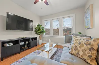 a living room with a couch and a flat screen tv at 2-Story Stay with Game Lounge & Free Parking Spots - 5 mins to NYC Train in Linden