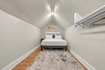 a white bedroom with a bed and a rug at 2-Story Stay with Game Lounge & Free Parking Spots - 5 mins to NYC Train in Linden