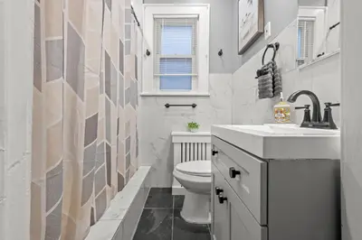 a bathroom with a white toilet and a sink at 2-Story Stay with Game Lounge & Free Parking Spots - 5 mins to NYC Train in Linden