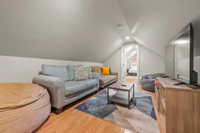 a living room with a couch and a tv at 2-Story Stay with Game Lounge & Free Parking Spots - 5 mins to NYC Train in Linden