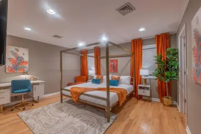 a bedroom with a canopy bed and a desk at The Orange Oasis in Bayonne