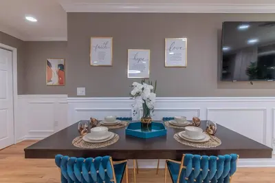 a dining room with a table and blue chairs at The Orange Oasis in Bayonne