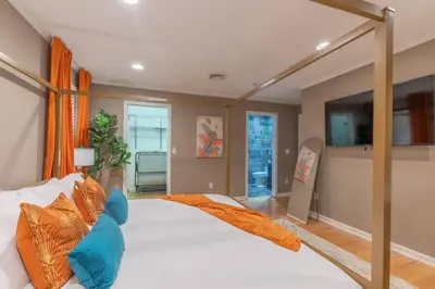 a bedroom with a large white bed with orange pillows at The Orange Oasis in Bayonne