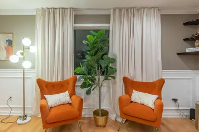 two orange chairs and a potted plant in a living room at The Orange Oasis in Bayonne