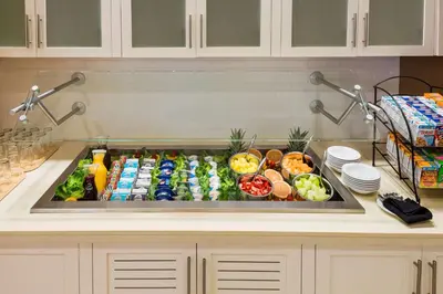 a kitchen counter with a sink full of food at Hilton Garden Inn Wayne in Wayne