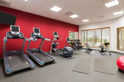 a fitness room with cardio equipment and red walls at Hilton Garden Inn Wayne in Wayne