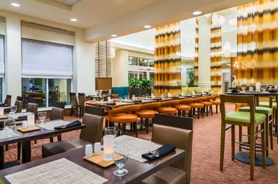 a restaurant with tables and chairs in a room at Hilton Garden Inn Wayne in Wayne